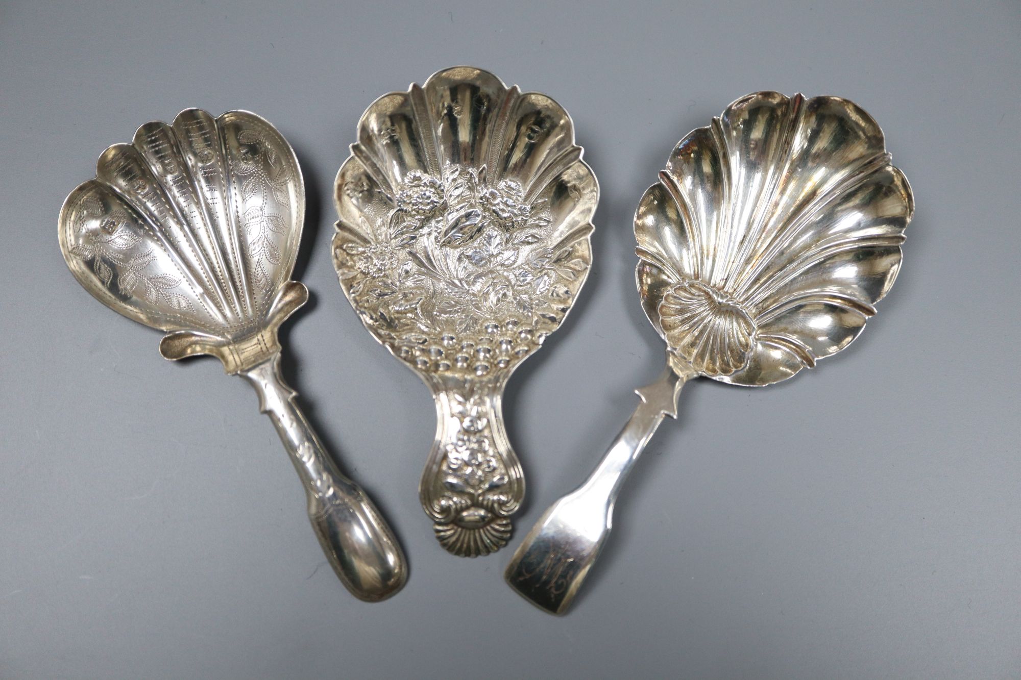 Three 19th century silver caddy spoons including embossed by Joseph Wilmore, Birmingham, 1825, 75mm.